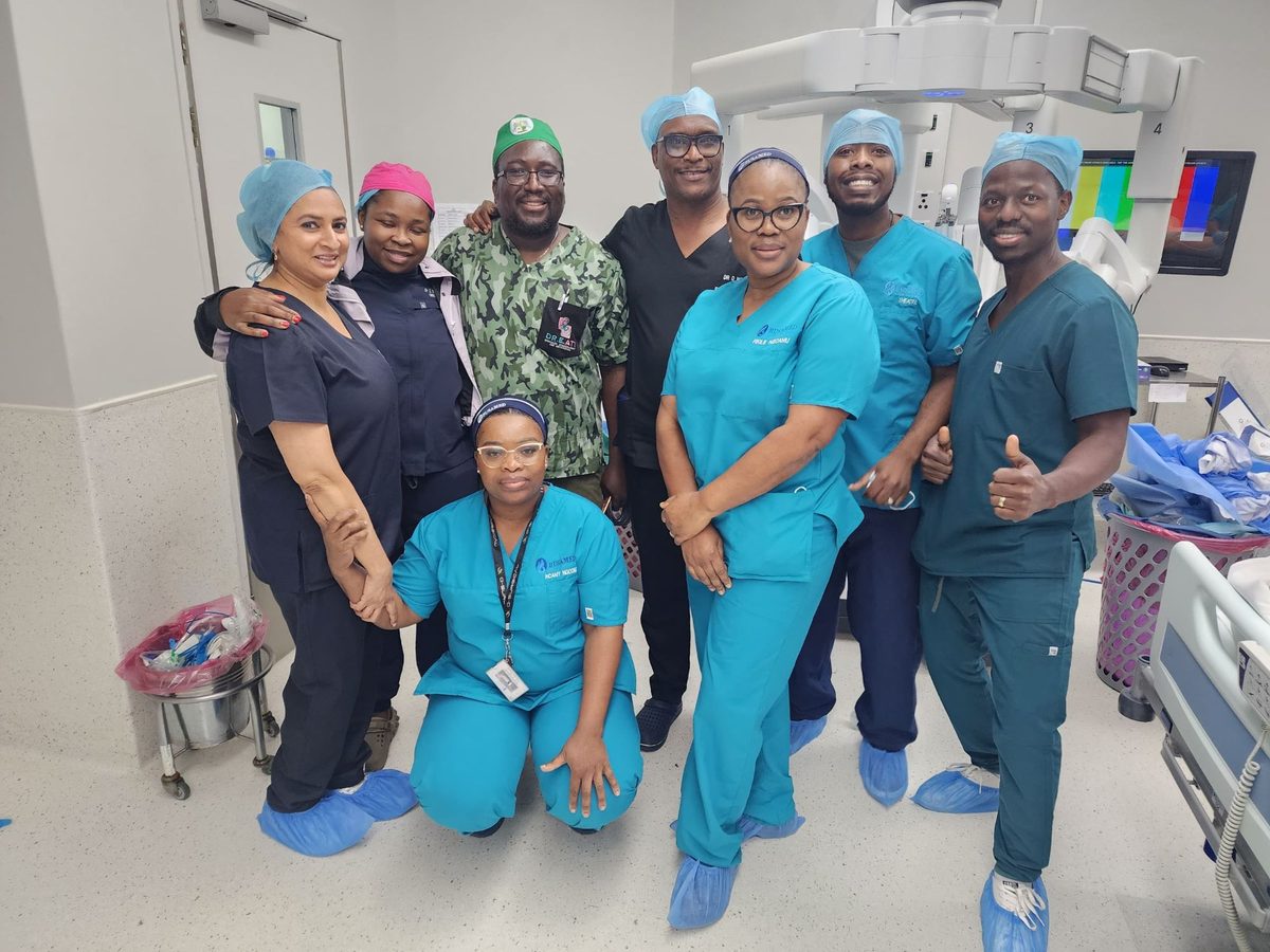 Theatre team standing in front of a da Vinci surgical robot